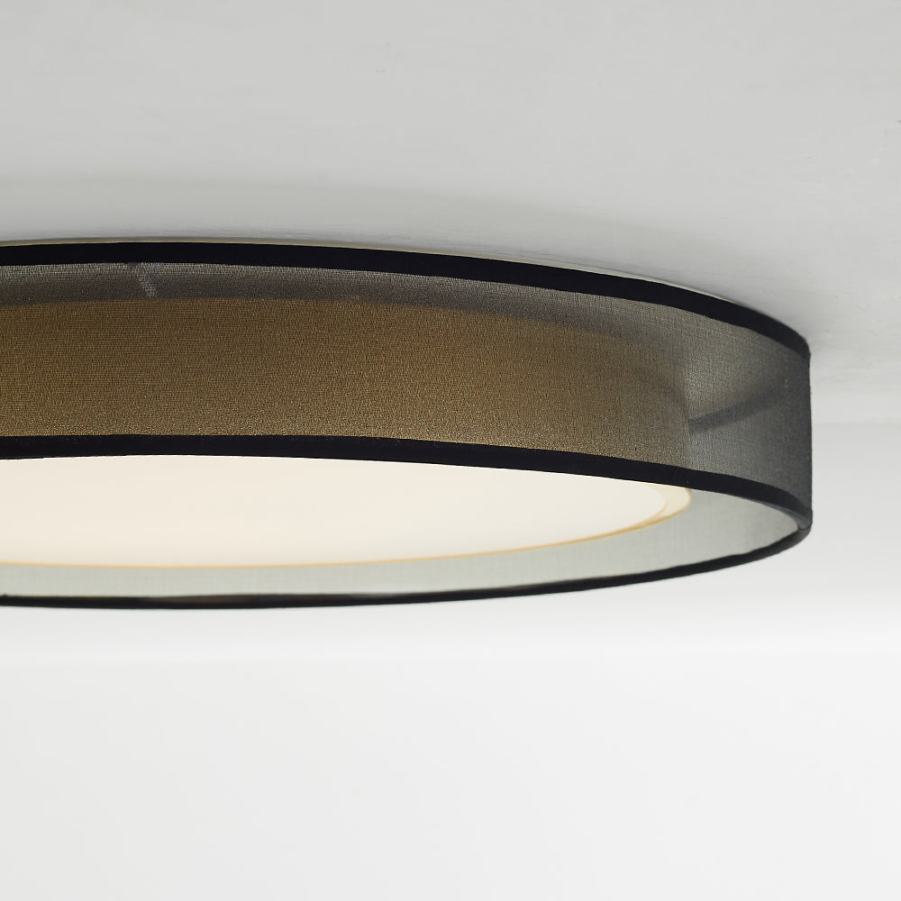 Side close-up of Quinn’s textured translucent grey drum and black rims, with the gold inner cylinder and glowing diffuser behind.