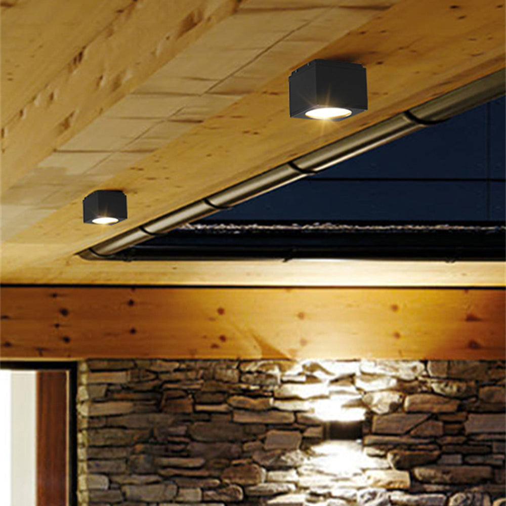 Black Orr lights beneath a timber eave and gutter above stone cladding, with a separate wall light below.
