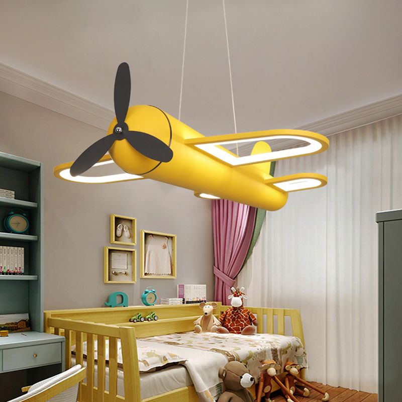 Yellow Minori airplane pendant illuminated above a bed.