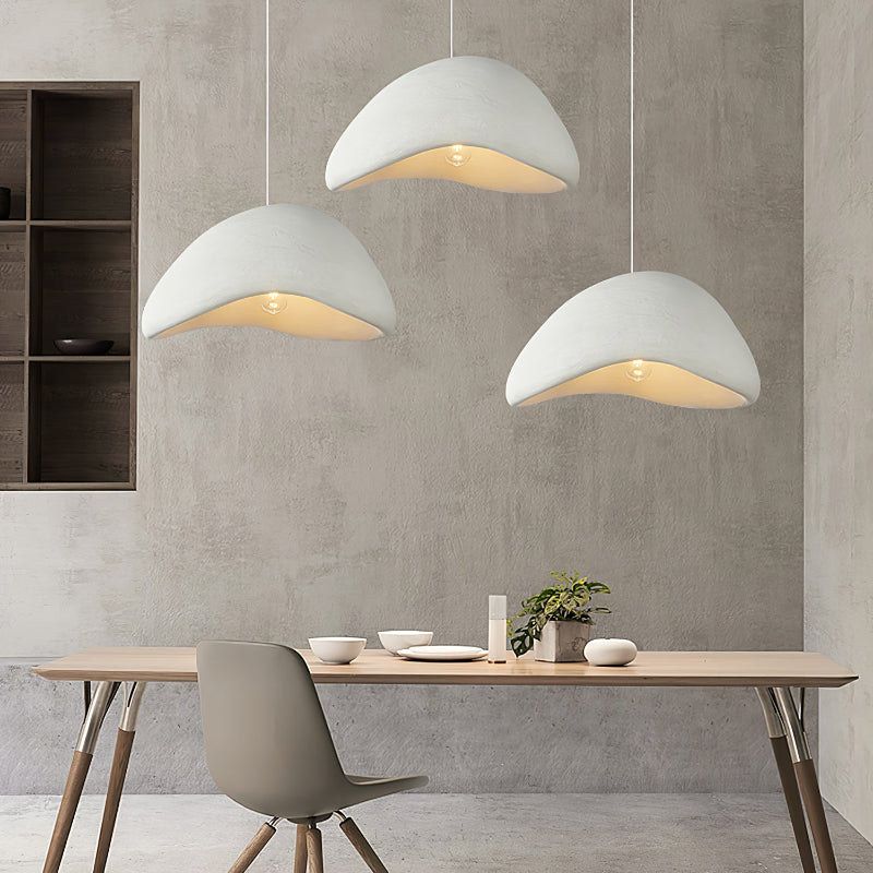 Three separate White cloud pendants at different heights above a rectangular light-wood dining table
