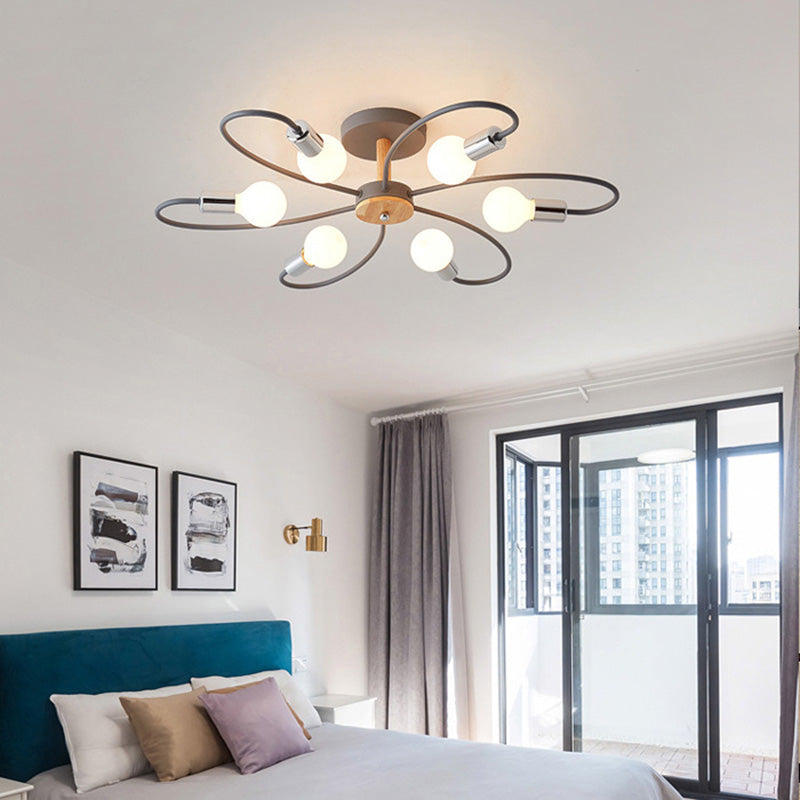 Gray six-head ceiling light glowing above a bed with teal headboard, pillows and a nearby window