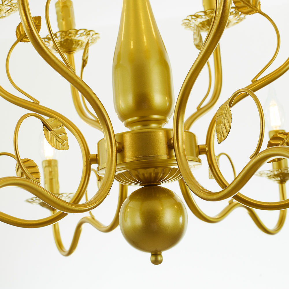 Gold Marilyn central stem and lower round finial close-up, surrounded by curled arms, slender leaf-decorated loops and candle holders.