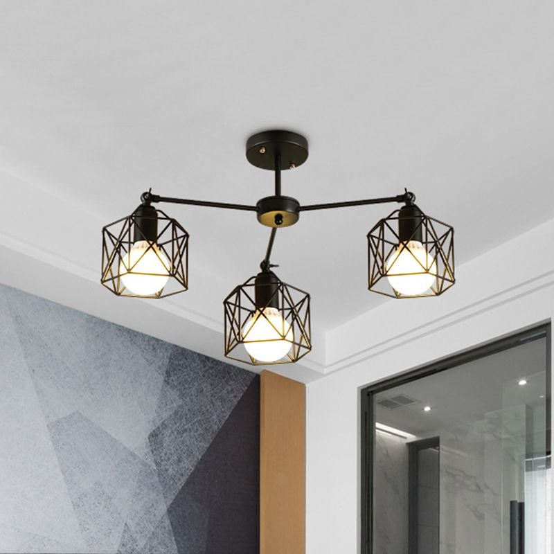 Three-light Herbert cage fitting near a grey geometric wall, wood-toned vertical panel and dark-framed glass opening.