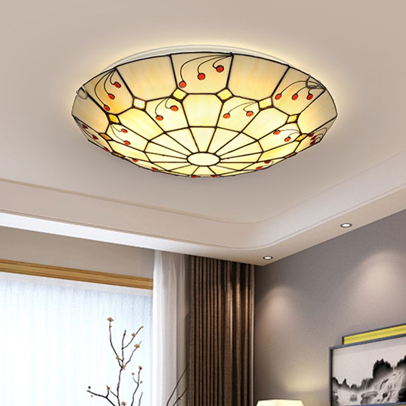 Eryn decorative bowl ceiling light glowing above a room with curtains.
