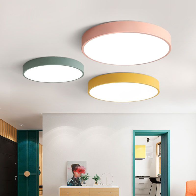 Green, pink and yellow Morandi ceiling lights in an interior with green doorframes, wood cabinetry, artwork and separate track spots.