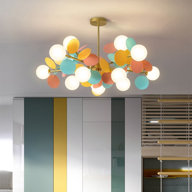 Jevon colourful petal ceiling light above teal, white and yellow cabinet panels beside window blinds.