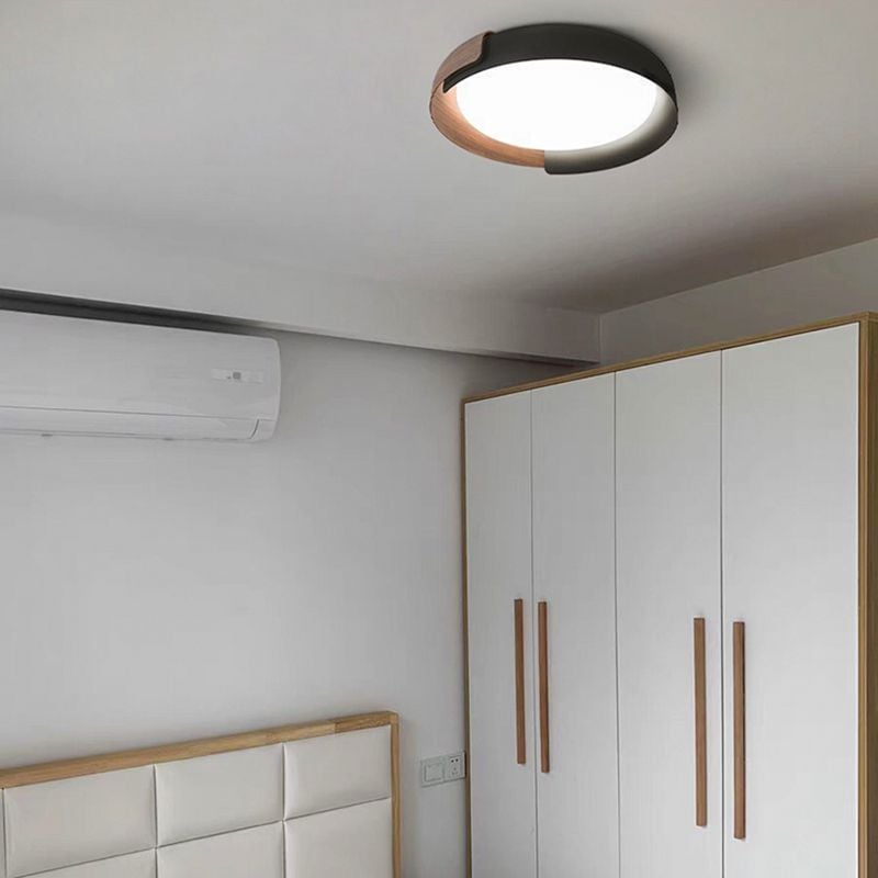 Wood-tone and black Quinn curved frame around a bright round face beside a wood-trimmed bedhead, white wardrobe and wall air conditioner.