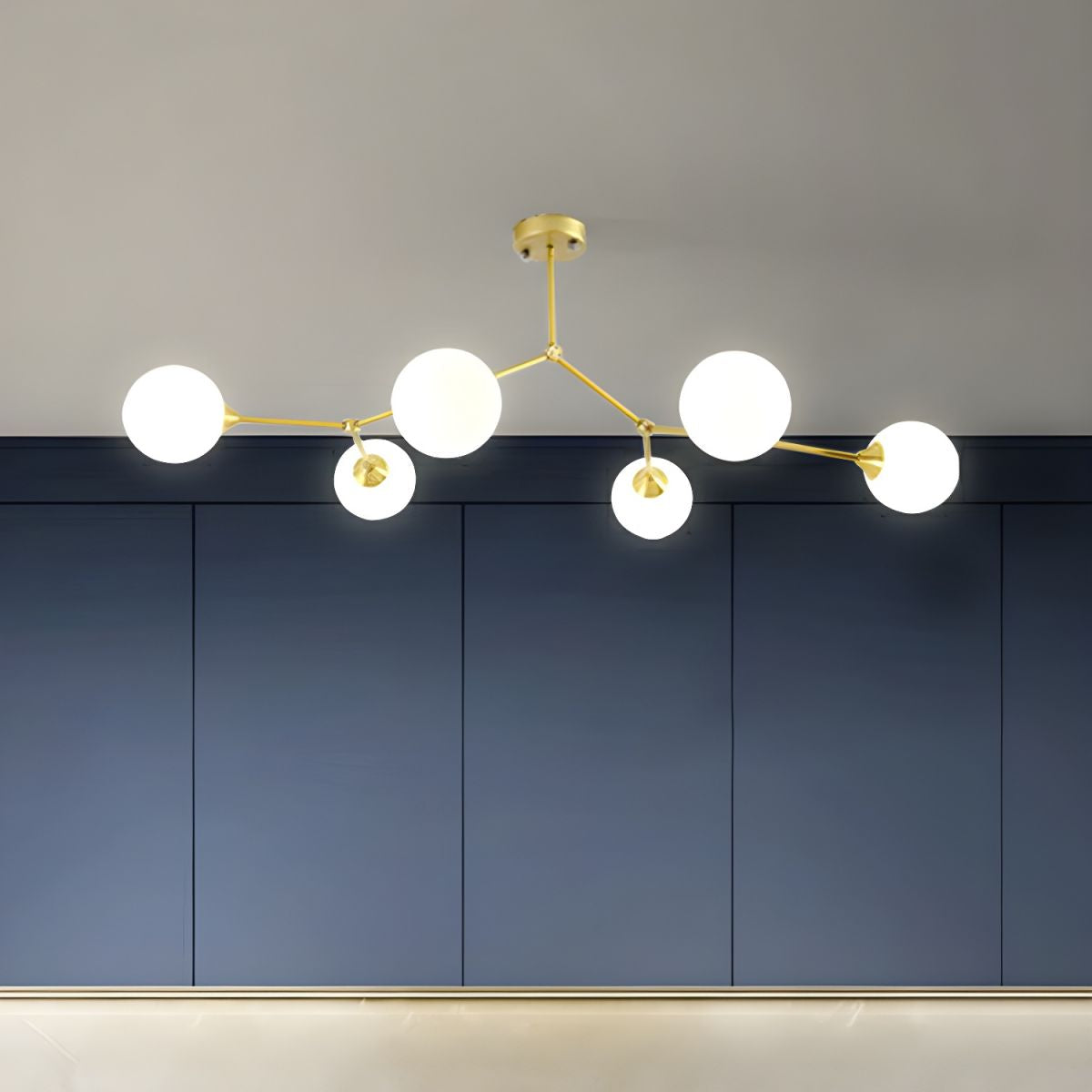 Gold-tone Valentina branch chandelier above an indoor dining area