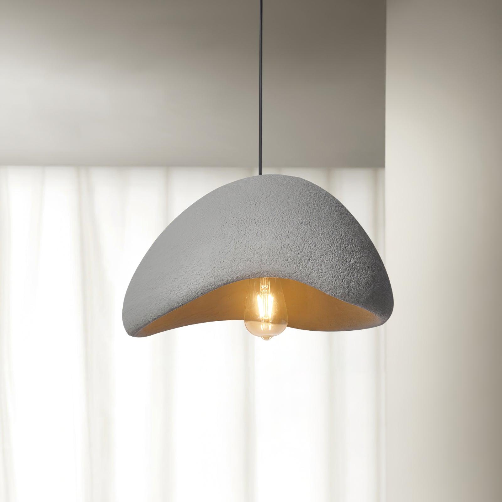 Close-up Gray cloud dome with a coarse speckled surface, black cord and exposed glowing bulb before curtains