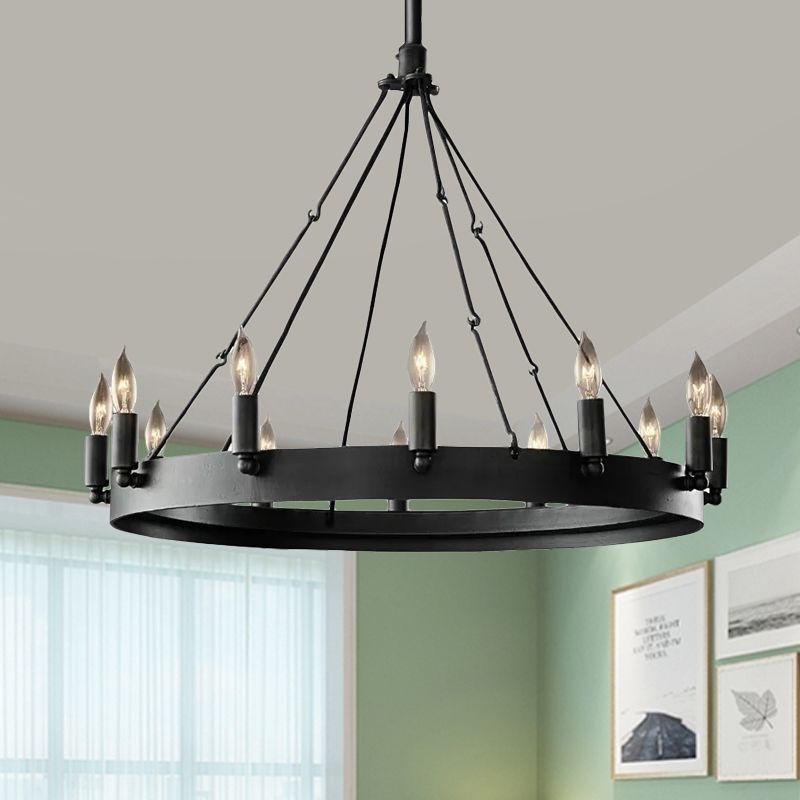 Black Alessio candle-style ring pendant hanging in a bright room beside curtains.