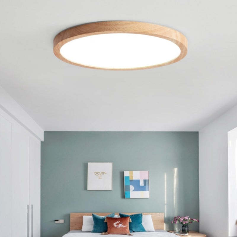 Ozawa wood-rim ceiling light above a bed against a blue-green wall