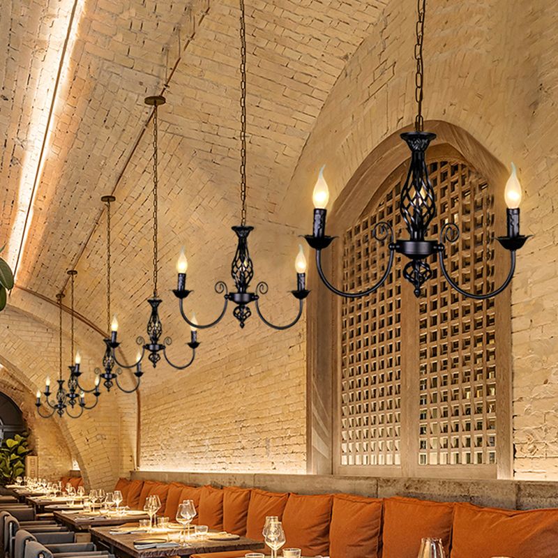 Black Silva three-light chandeliers along vaulted brick restaurant ceiling above orange banquette and dining tables