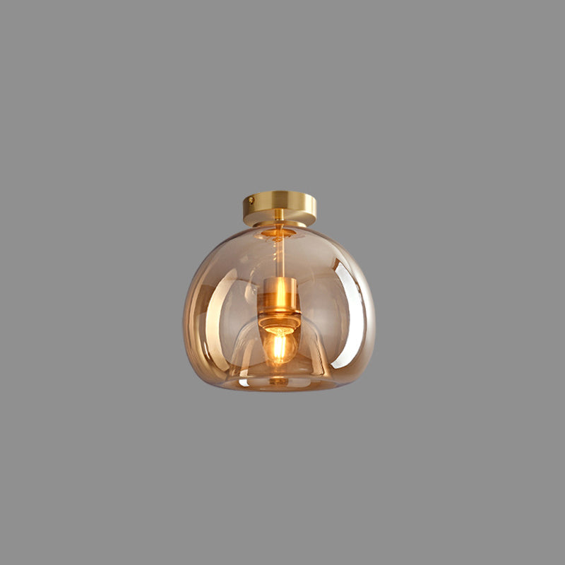 Gold Sanna short-stem ceiling light isolated on grey background with round canopy, tinted dome glass and visible bulb.