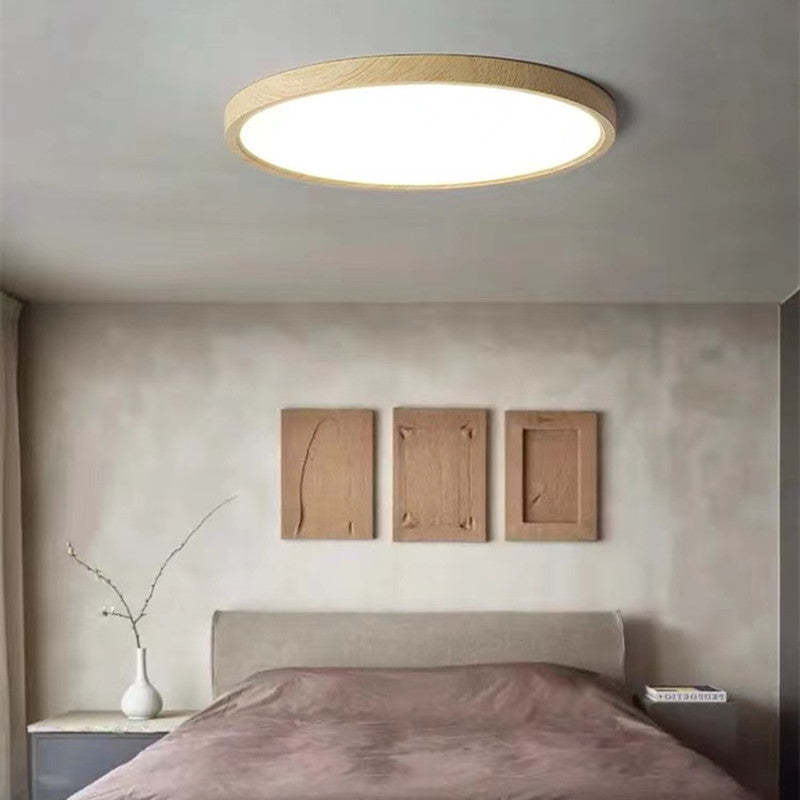 Ozawa wood-rim ceiling light above a bed in a neutral bedroom