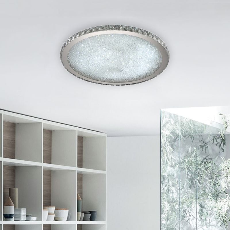 Clear Kristy ceiling light illuminated above white shelves
