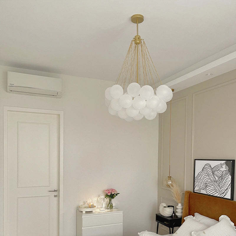 Unlit gold-and-white globe cluster in a bedroom