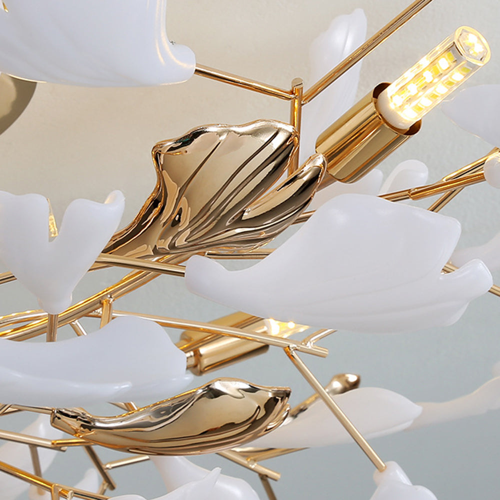 Olivia detail with layered white and glossy gold-tone fan leaves, crossing rods and a lit tubular source.