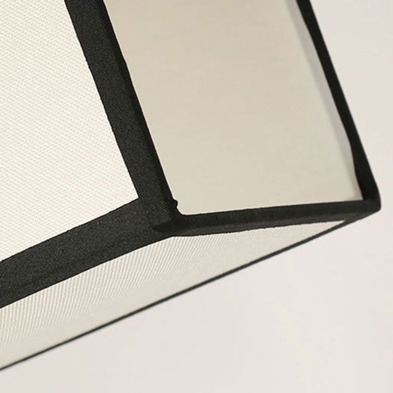Close-up of pale woven fabric and dark rectangular shade edging