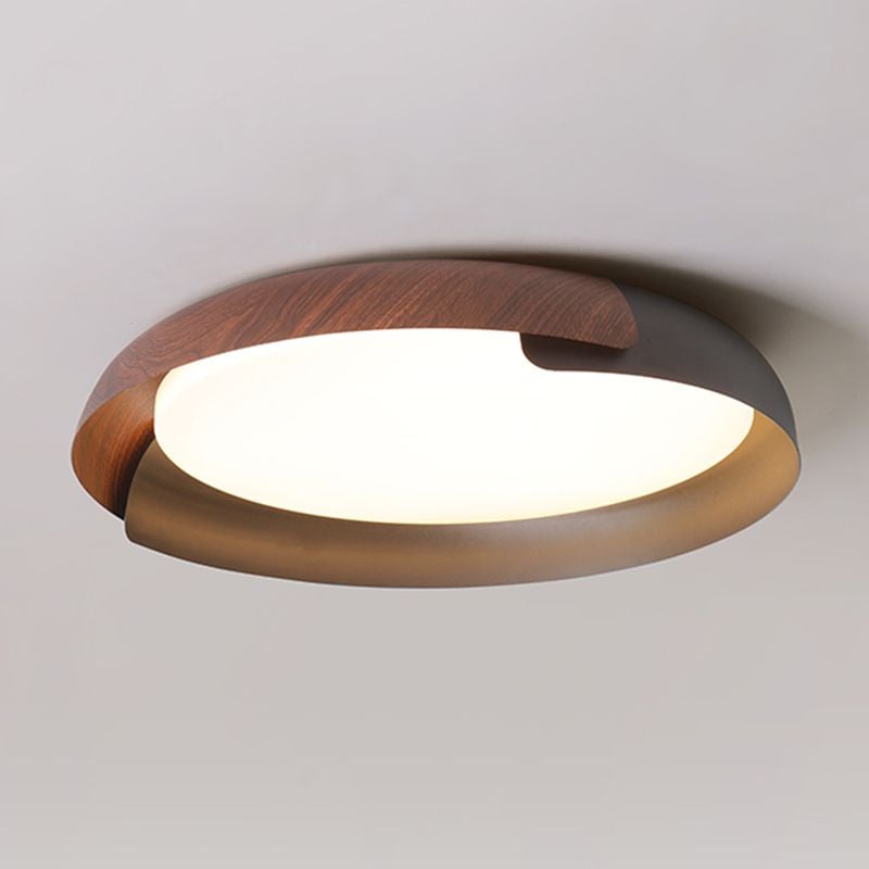 Close view of a bright circular Quinn light face inside overlapping wood-tone and black bands with warm reflections along the inner rim.