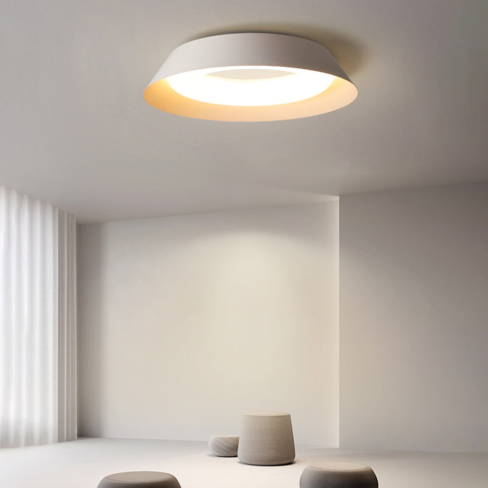 Quinn white bowl ceiling light near a curtained window above three pale rounded stools in a minimal room.