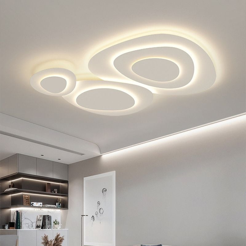 Lit Valentina curved fixture above gray shelving, books, plants and framed artwork, with separate shelf lighting in the room.