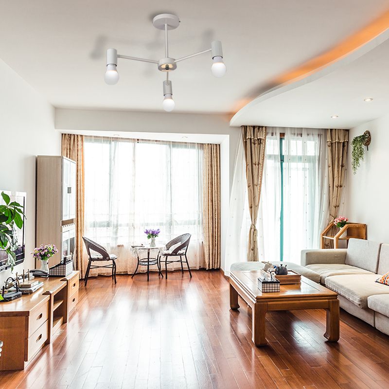 White three-light ceiling fixture above a bright living room with sofa, wooden floor and curtained windows