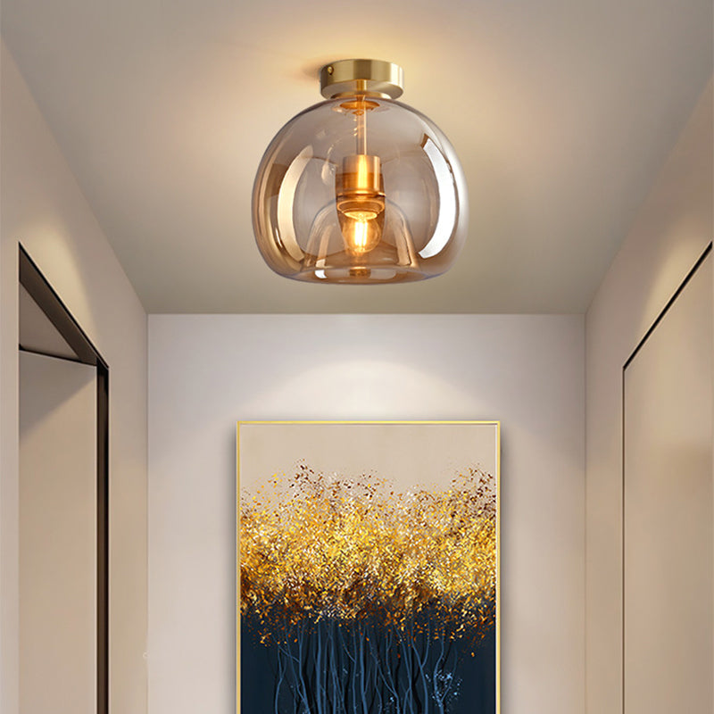 Gold Sanna short-stem ceiling light above gold-framed yellow tree artwork on a cream hallway wall.