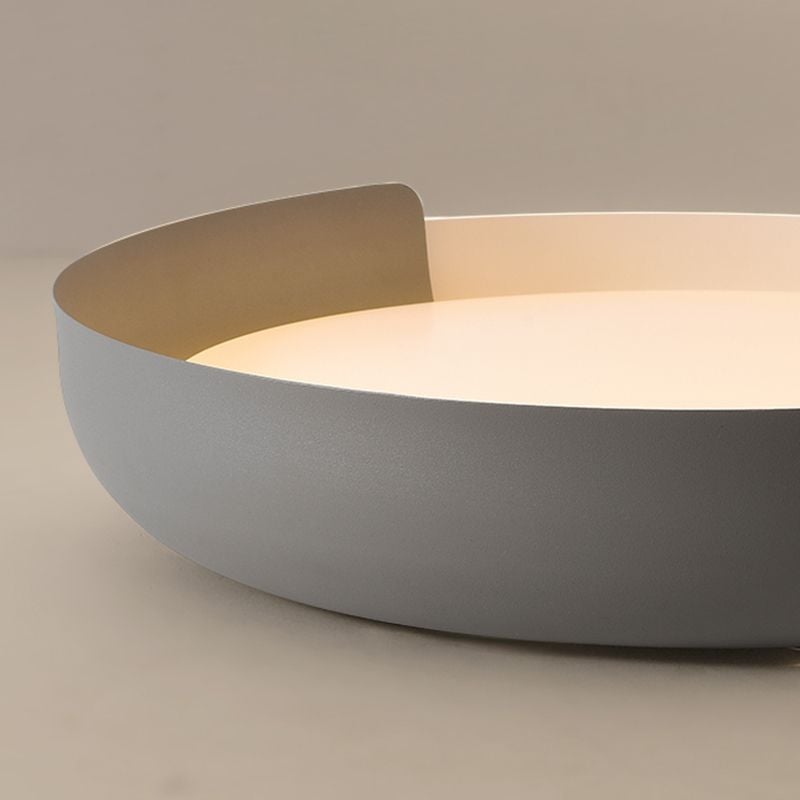 Side detail of a gray Quinn curved band rising past a pale band around a warm-lit circular face.