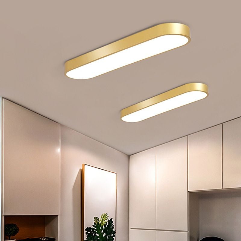 Two gold Quinn ceiling lights with smooth sides above pale wardrobe panels, a gold-edged mirror and a green plant.