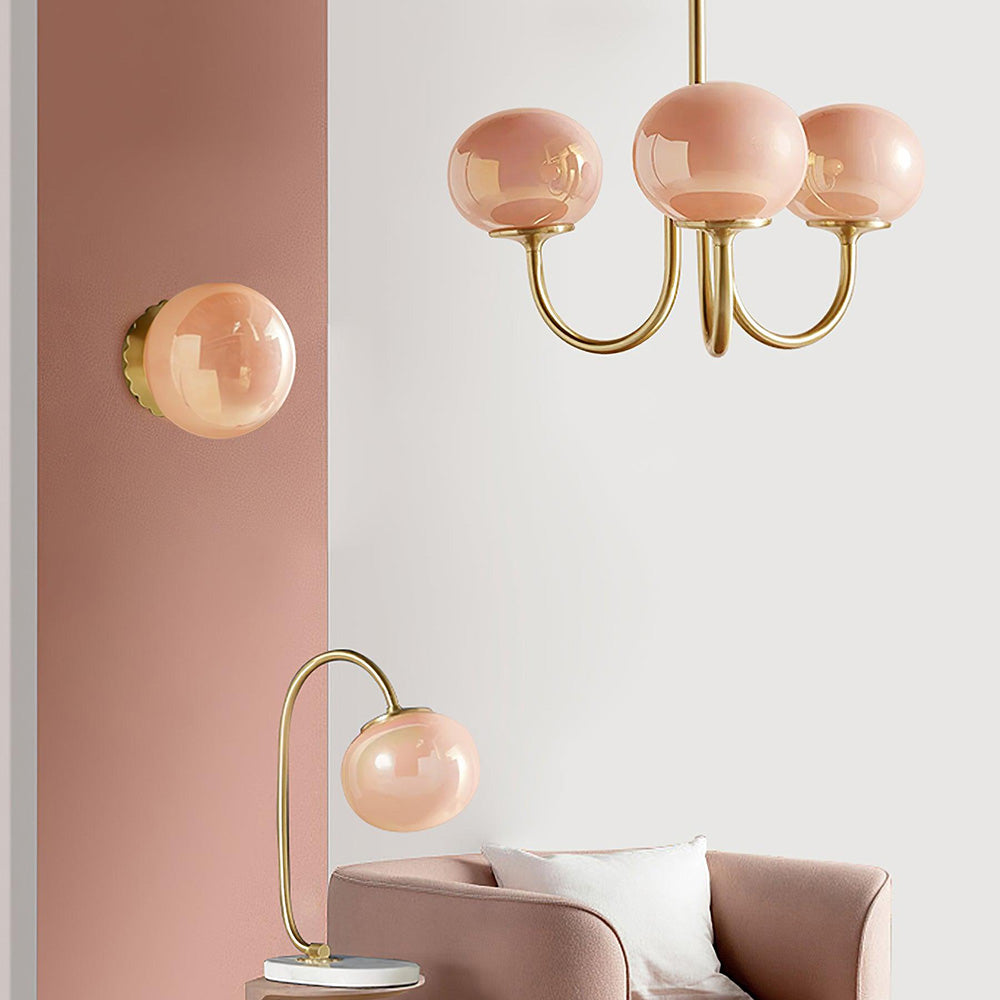 Pink three-globe chandelier in a room with separate matching lights