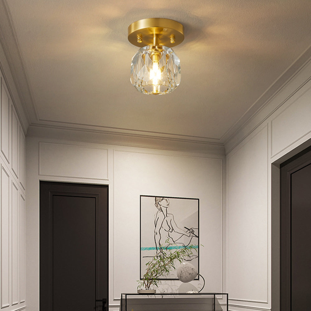 Kirsten light in a white-paneled hall with black doors, console, line-drawing art, green branches and white orb ornament.