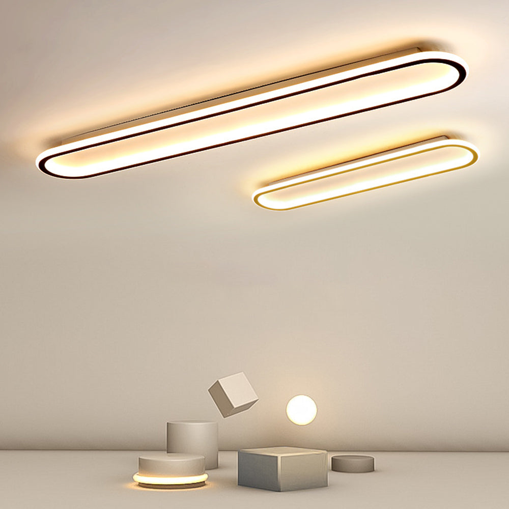 Large Black and smaller Gold Quinn fixtures above grey cubes, cylinders and a luminous sphere in a display arrangement.