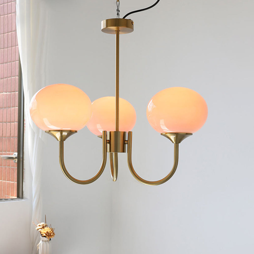 Illuminated pink three-globe chandelier with ceiling canopy