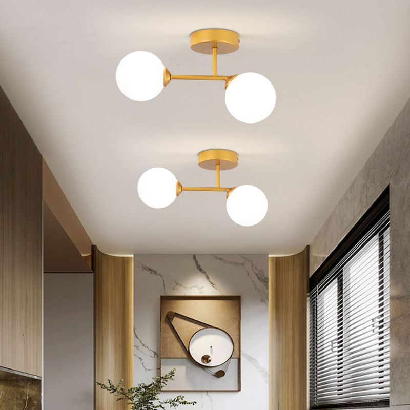 Gold Valentina fittings in a wood-trimmed indoor hall with dark blinds, plants and geometric wall artwork.