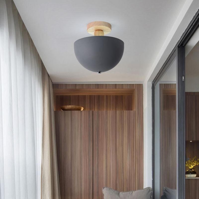 Gray Ozawa Bowl ceiling light with wooden canopy and rounded shade underside, beside sheer curtains, wood wall and dark glass