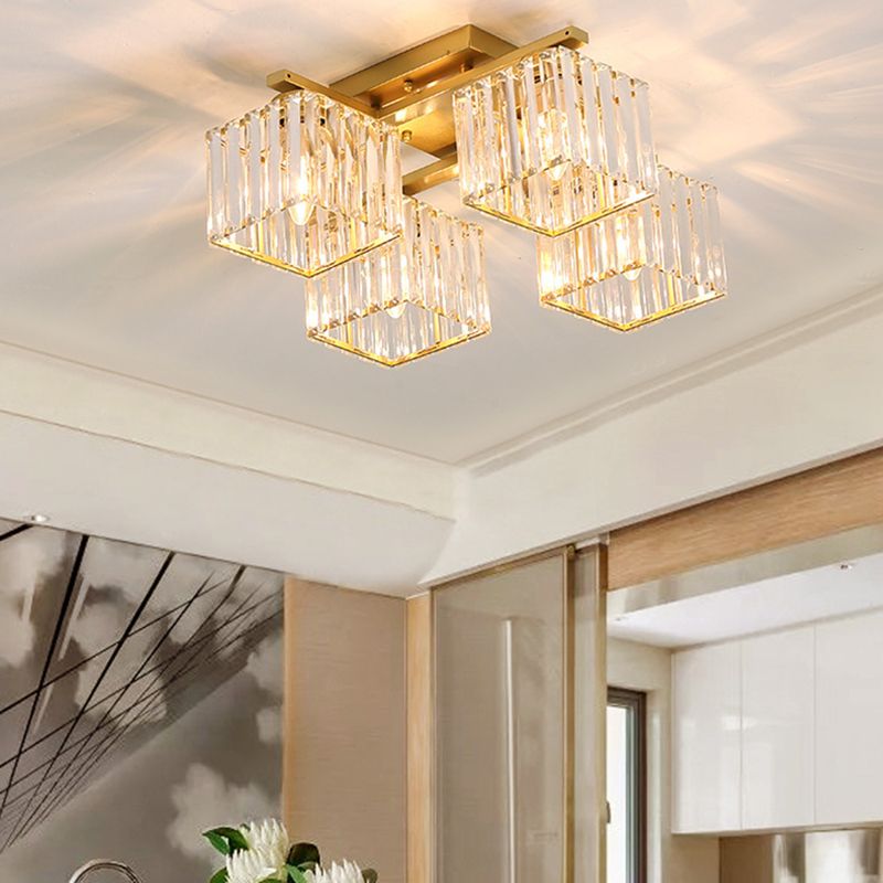 4-light Gold Kristy light near tan translucent door panels, pale branch artwork and white flowers, with lit example bulbs.