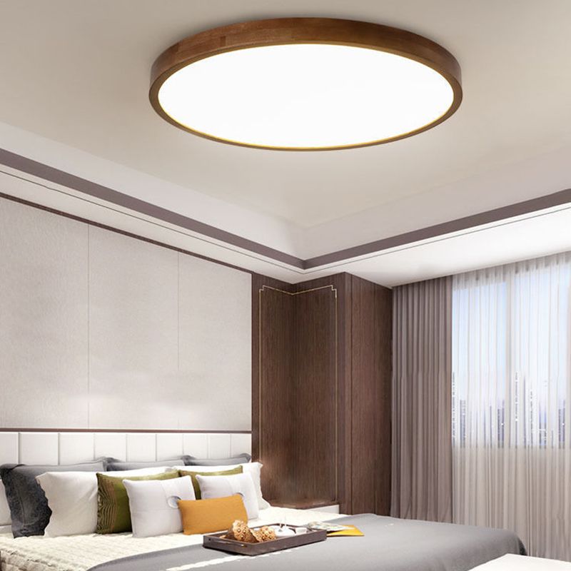 Round Ozawa ceiling light above a pale headboard, timber wall panels, sheer curtains and white, green and gold pillows.
