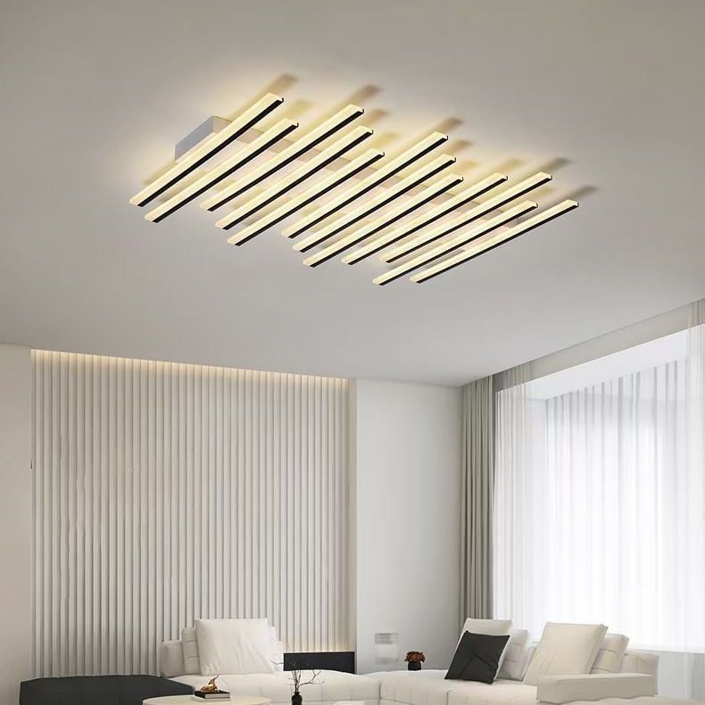 Quinn ceiling fixture above white seating and dark cushions beside sheer curtains and a wall with vertical strips.