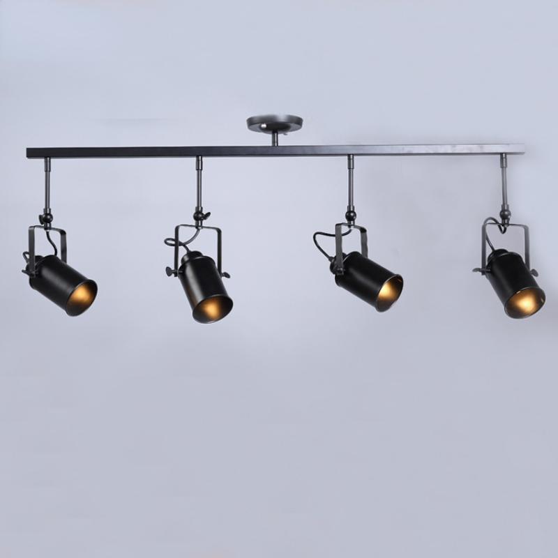 Front view of Alessio four-head black bar, with alternating head directions, square brackets and round canopy.