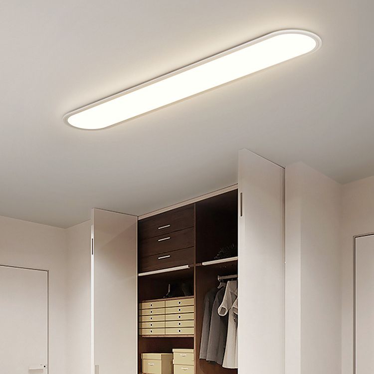 White Edge ceiling light over an open wardrobe with dark drawers, stacked storage boxes, a hanging jacket and white doors.