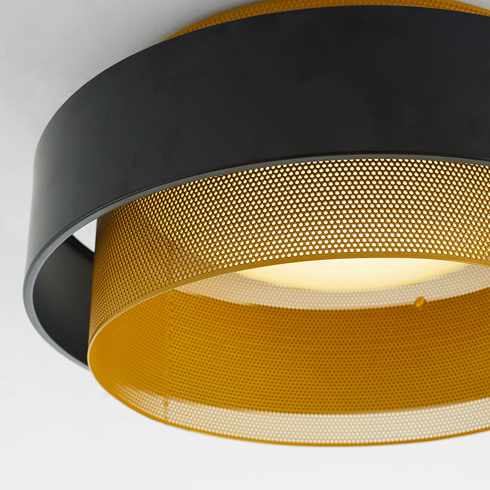 Low-angle close-up of the Quinn black outer band, gold-tone perforated ring, connecting gap and pale central disc.