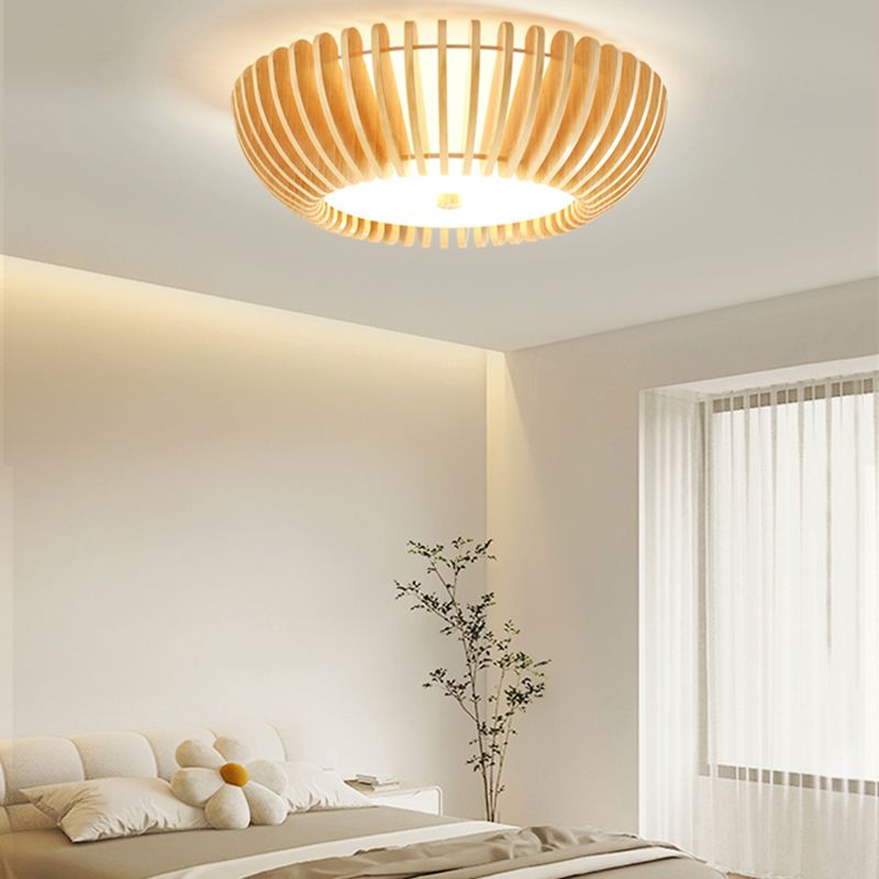 Ozawa ceiling light above a cream scalloped headboard and flower-shaped cushion, beside sheer curtains and a tall green plant.
