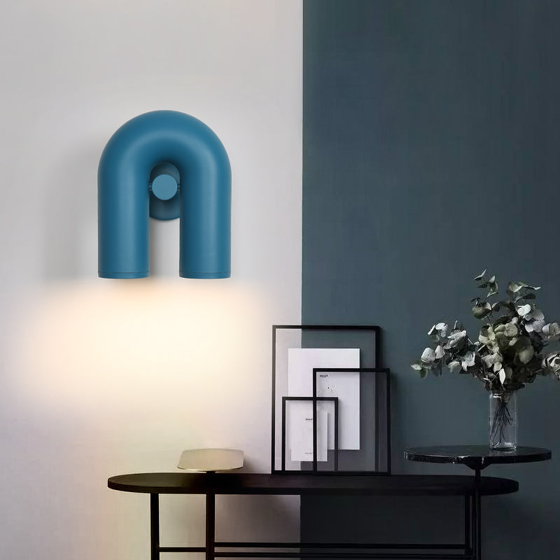 Blue option photo, U-shaped light on white and blue wall above dark console with picture frames, pale dish and leafy vase