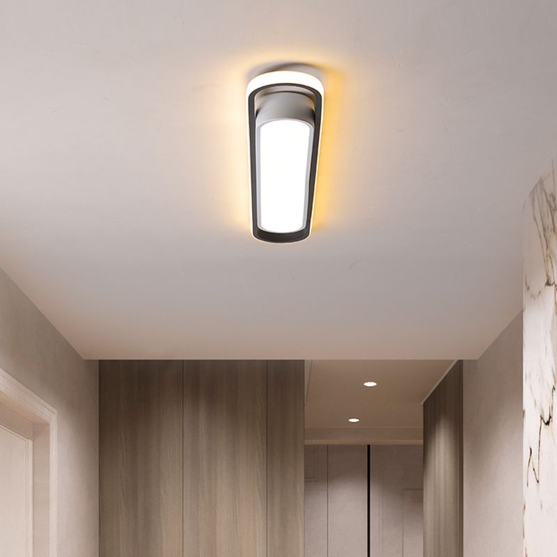 End view of a lit linear ceiling fixture over a corridor with wooden wall panels and ceiling downlights