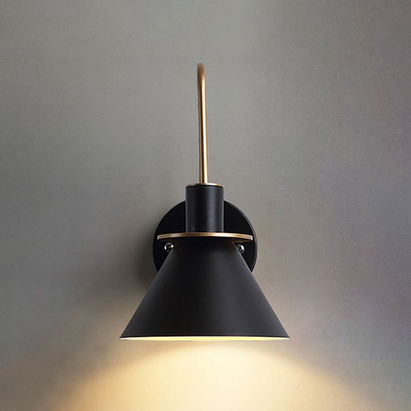 Front view of black flared shade, round plate and gold-coloured rim with light beneath the opening