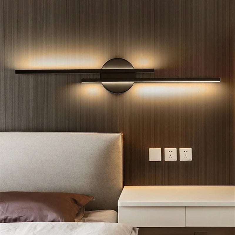 Black offset light bars above a bed and wall switches