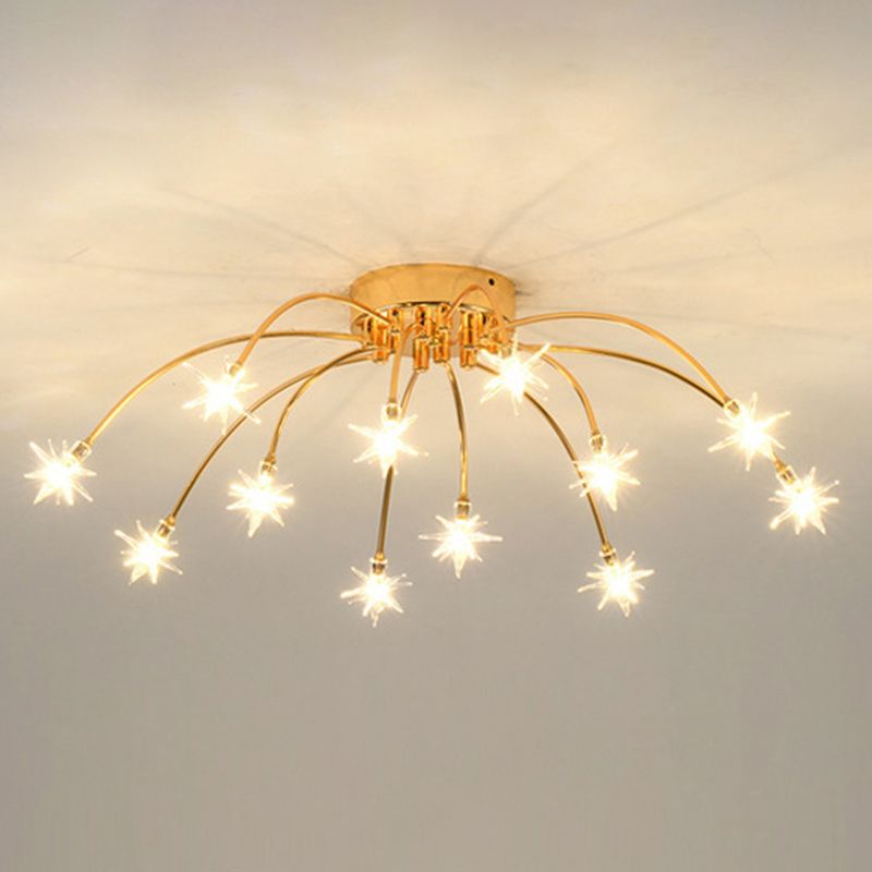 12-light Gold reference with curved radial arms, round canopy and warm-looking lit glass stars on pale ceiling