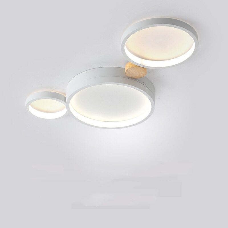 White three-head ceiling light with one large round disc between two smaller discs