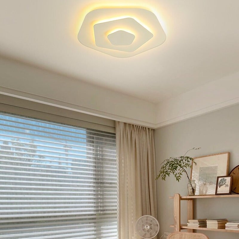 White Quinn polygonal ceiling light in a bright room with blinds