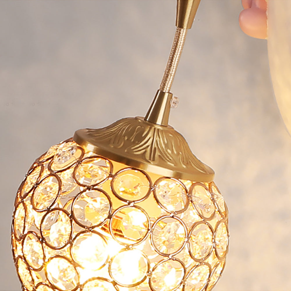 Detail of hanging connector, leaf-pattern gold-tone cap and rounded shade with clear faceted elements